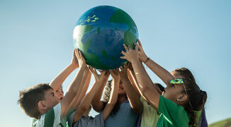 Children holding up planet