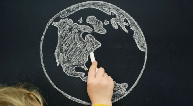 Image of world on blackboard with child