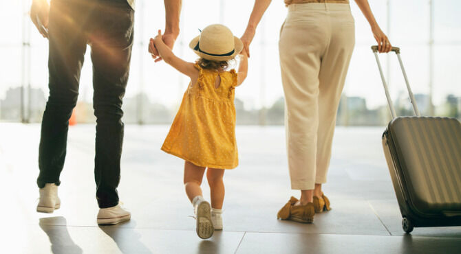 Two parents holding hands of a small child