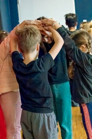 CIS-group-children-standing-in-circle-arms-in-air